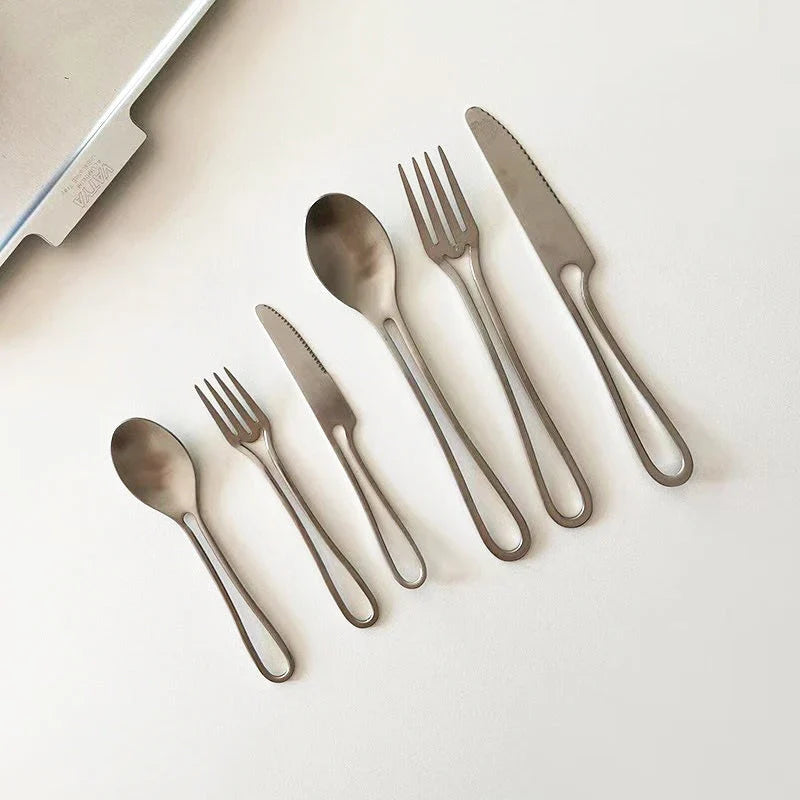 Sleek and modern 304 stainless steel cutlery set with a black finish, including knife, fork, and spoon for dinner and dessert.
