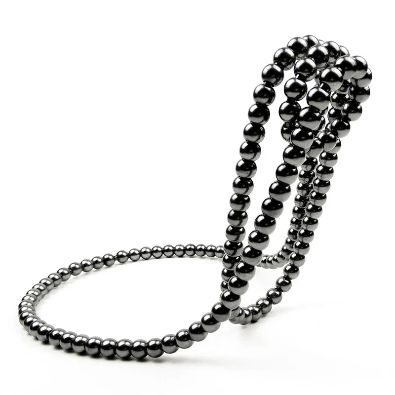 Elegant white iron wine rack with pearl necklace-inspired design, displayed on a desktop or shelf