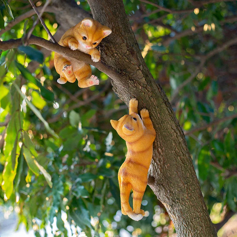 Charming resin cat statue with lifelike details, climbing on a tree branch and adding whimsical flair to any garden or indoor space.
