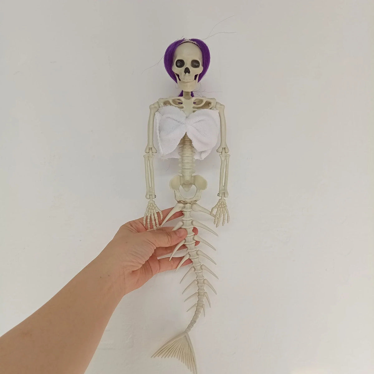 Mermaid bone pendant in various colors, including brown, dark purple, burgundy, and lake blue, hanging outdoors for Halloween decoration