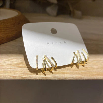 Elegant gold-toned zircon four-claw stud earrings with a classic cuff design, offering a sparkling and sophisticated look.