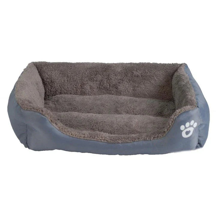 A plush, green pet bed with a paw-print pattern, designed to provide cozy and waterproof comfort for pets.