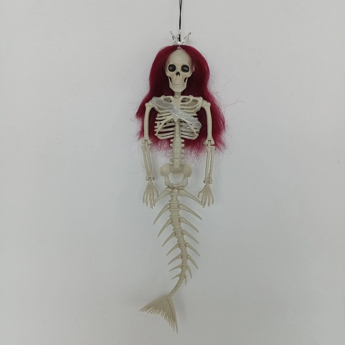 Mermaid bone pendant in various colors, including brown, dark purple, burgundy, and lake blue, hanging outdoors for Halloween decoration