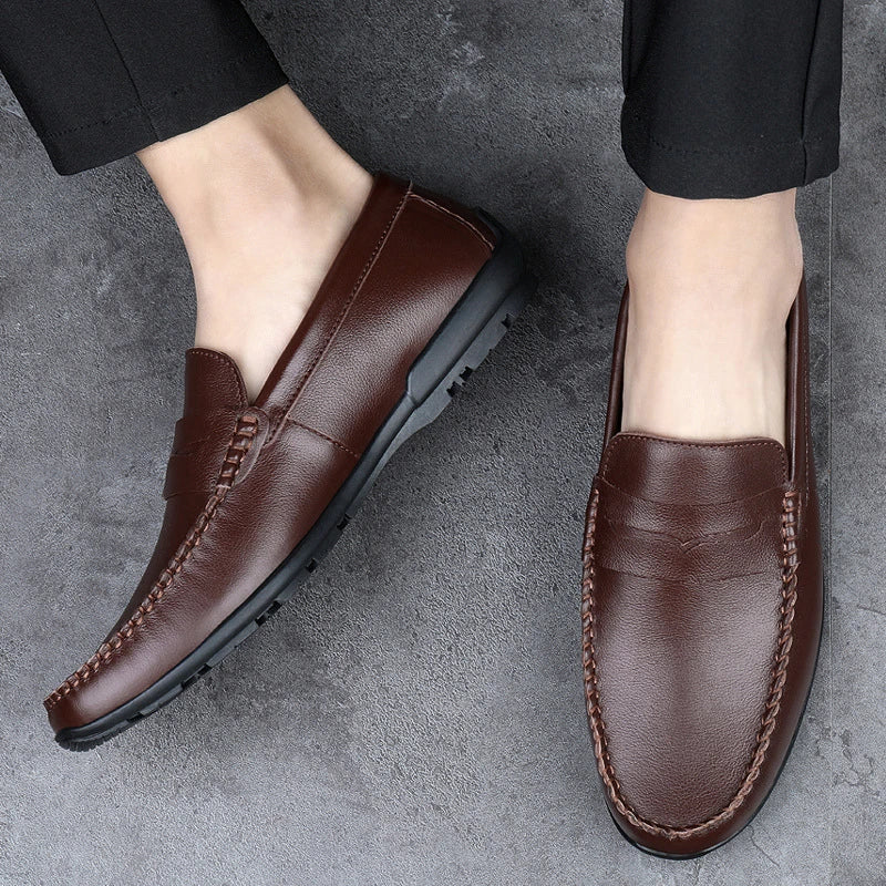 Men's driving shoes in black cowhide leather with sleek, round-toe design for superior driving control and style