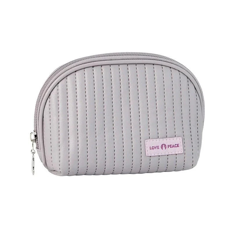 Stylish compact makeup bag made of premium PU leather in light blue color, with a sleek minimalist design for modern women