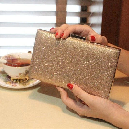 A shiny, metallic dinner clutch bag with a detachable chain strap for versatile carrying options