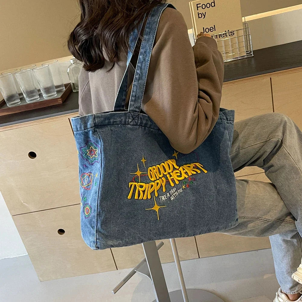A stylish denim shoulder bag with embroidered details, perfect for everyday use and carrying all your essentials