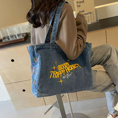 A stylish denim shoulder bag with embroidered details, perfect for everyday use and carrying all your essentials