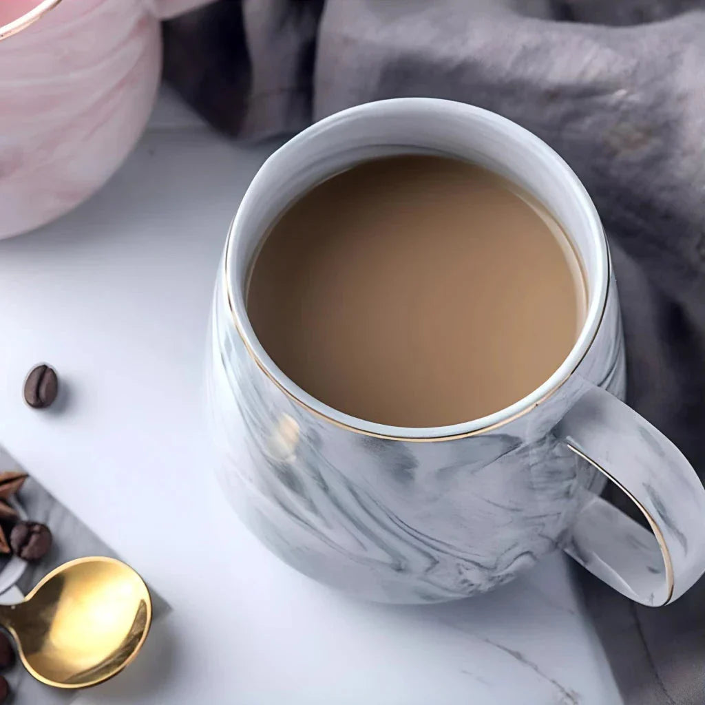 Elegant marble pattern ceramic mug with a gold rim, perfect for coffee, tea, and other hot and cold beverages