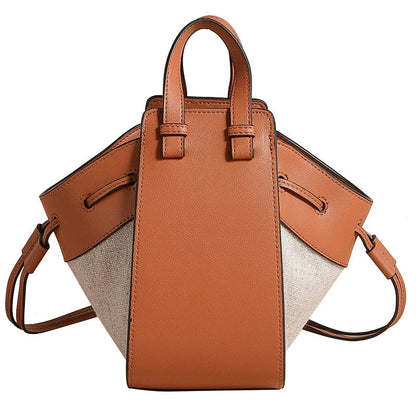 A stylish drawstring bucket bag made from premium cowhide leather and canvas, featuring a spacious main compartment, adjustable shoulder strap, and a softly structured design.