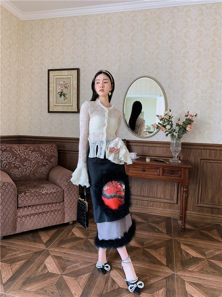 Elegant lace patchwork blouse with ruffled long sleeves and a button-down front in a classic off-white and black color palette.