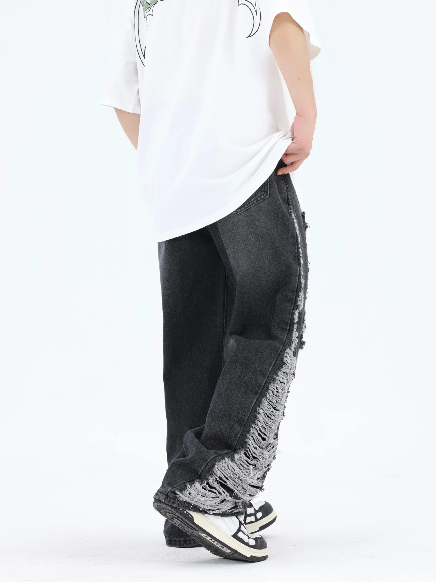 Premium loose fit distressed denim trousers for men and women, featuring a relaxed silhouette, high-quality cotton construction, and trendy distressed details.