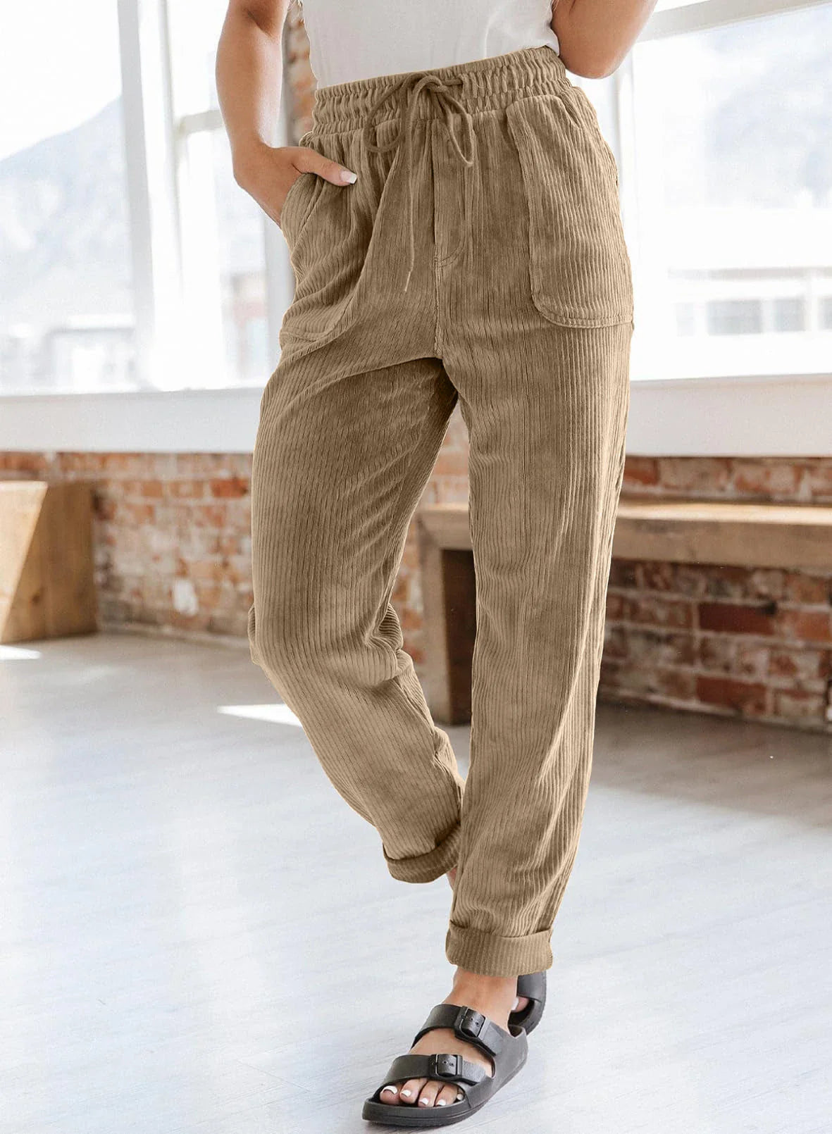 A pair of stylish corduroy pants for women with a wide-leg silhouette, elastic waistband, and side pockets.