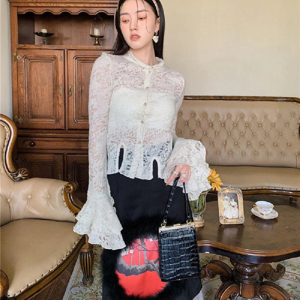 Elegant lace patchwork blouse with ruffled long sleeves and a button-down front in a classic off-white and black color palette.