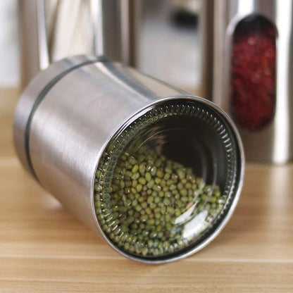 Stainless steel and glass spice jars in various sizes with airtight lids, perfect for organizing and preserving spices in a modern kitchen.