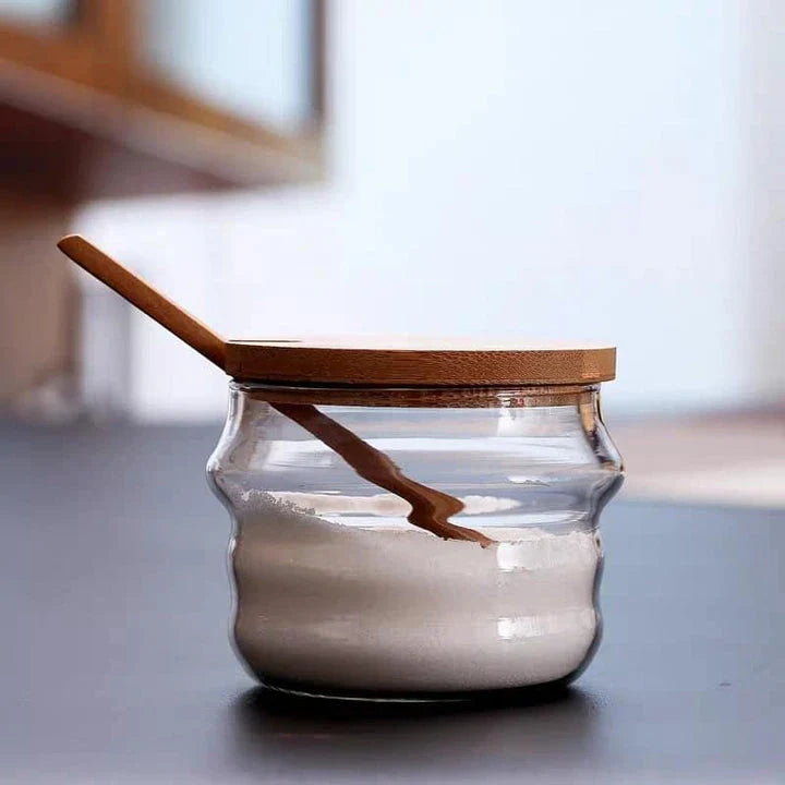 Elegant glass canister with a wooden spoon, featuring a transparent design for easy visibility of contents