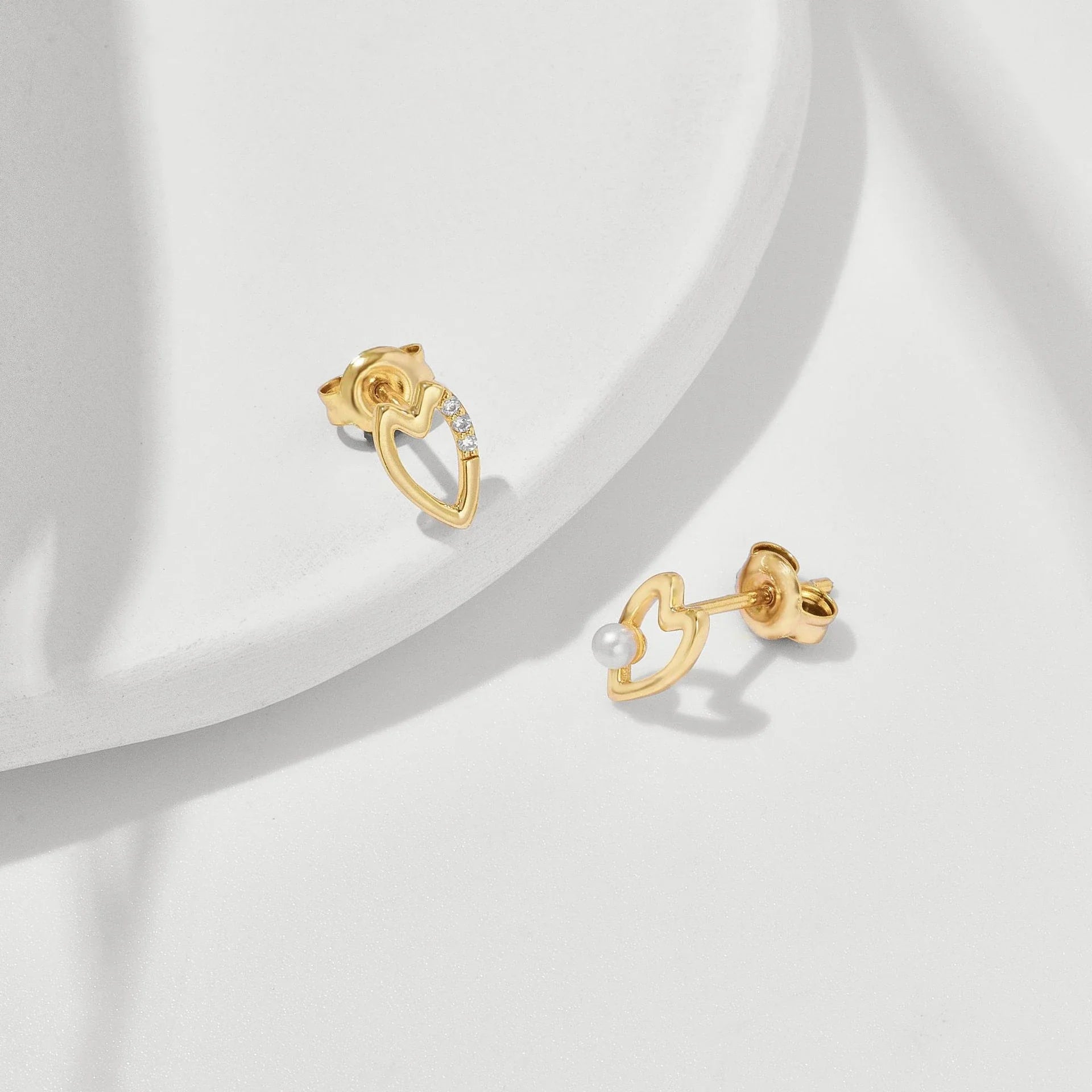Elegant mini freshwater pearl stud earrings in 925 sterling silver with a sleek geometric design