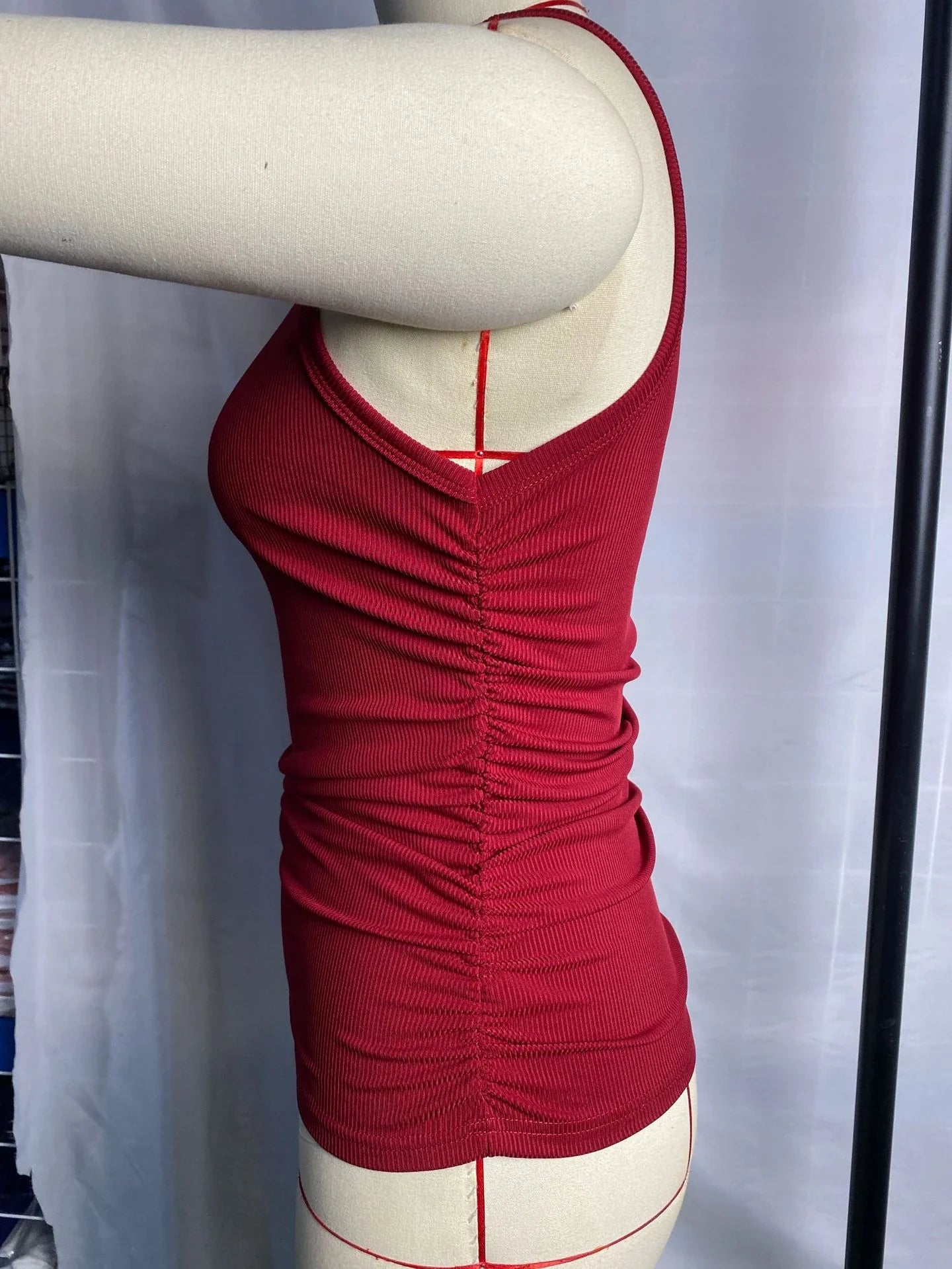 A sleeveless ribbed knit tank top for women in a variety of colors and sizes, featuring a crew neck design and pleated details for a stylish, casual look.