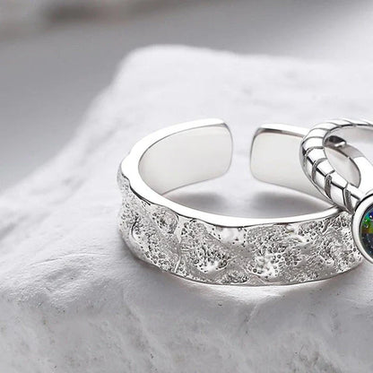 A sterling silver couple's ring set featuring a captivating glass design and an adjustable fit