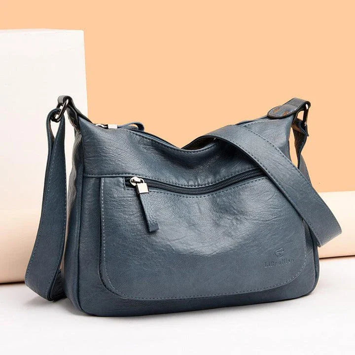 Stylish one-shoulder messenger bag in various colors with a soft, supple PU leather exterior and a spacious, organized main compartment