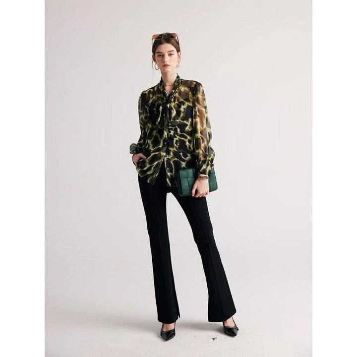A silk blend blouse with a camouflage print and a bow collar, designed for versatile wear.