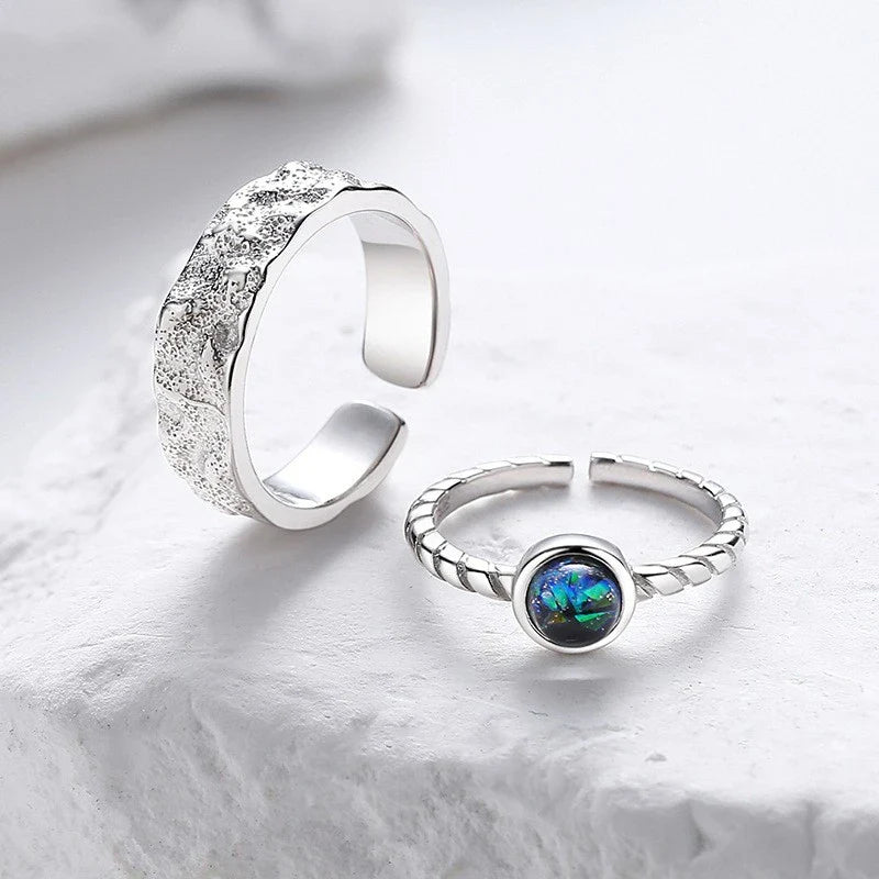 A sterling silver couple's ring set featuring a captivating glass design and an adjustable fit