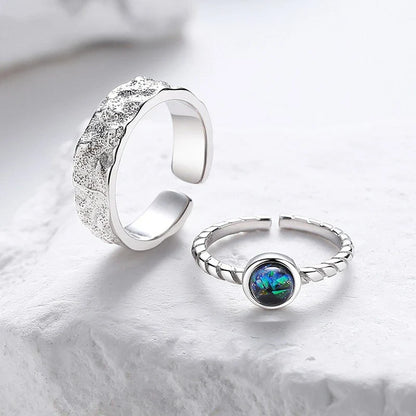 A sterling silver couple's ring set featuring a captivating glass design and an adjustable fit