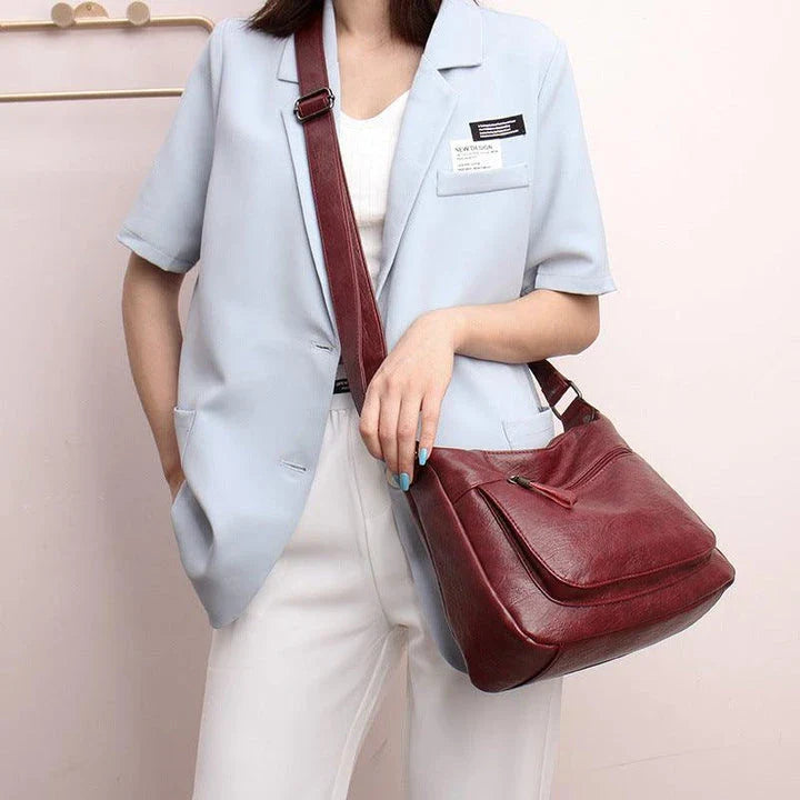 Stylish one-shoulder messenger bag in various colors with a soft, supple PU leather exterior and a spacious, organized main compartment
