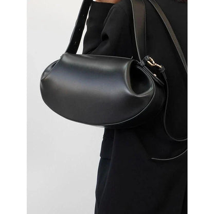 Circular vegan leather handbag in a tan color, with a sturdy build and thoughtful interior design for versatile use.