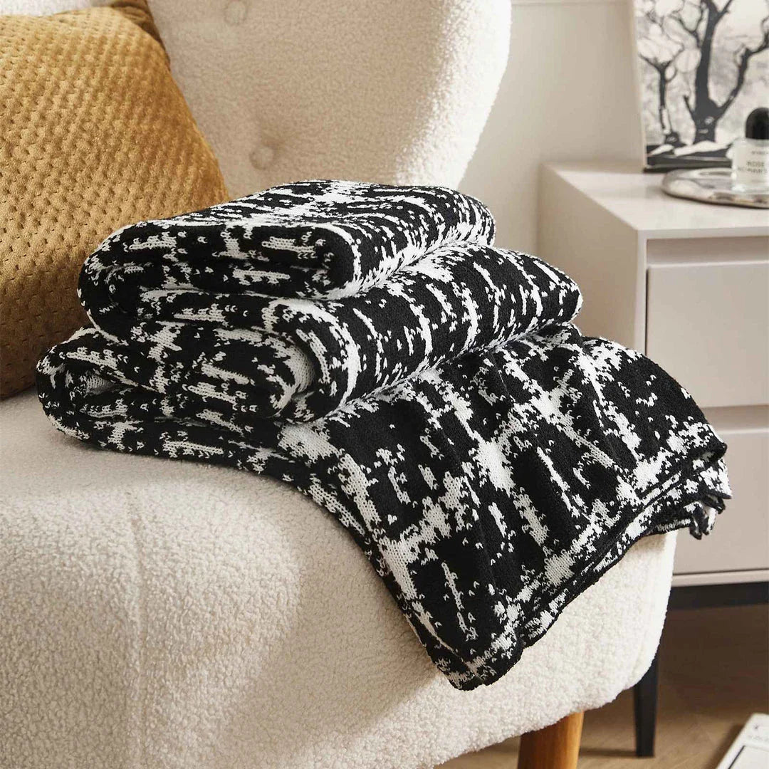 Luxurious white and black plaid wool knit blanket for cozy home, travel, and relaxation