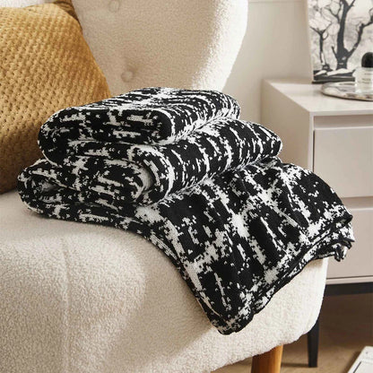 Luxurious white and black plaid wool knit blanket for cozy home, travel, and relaxation
