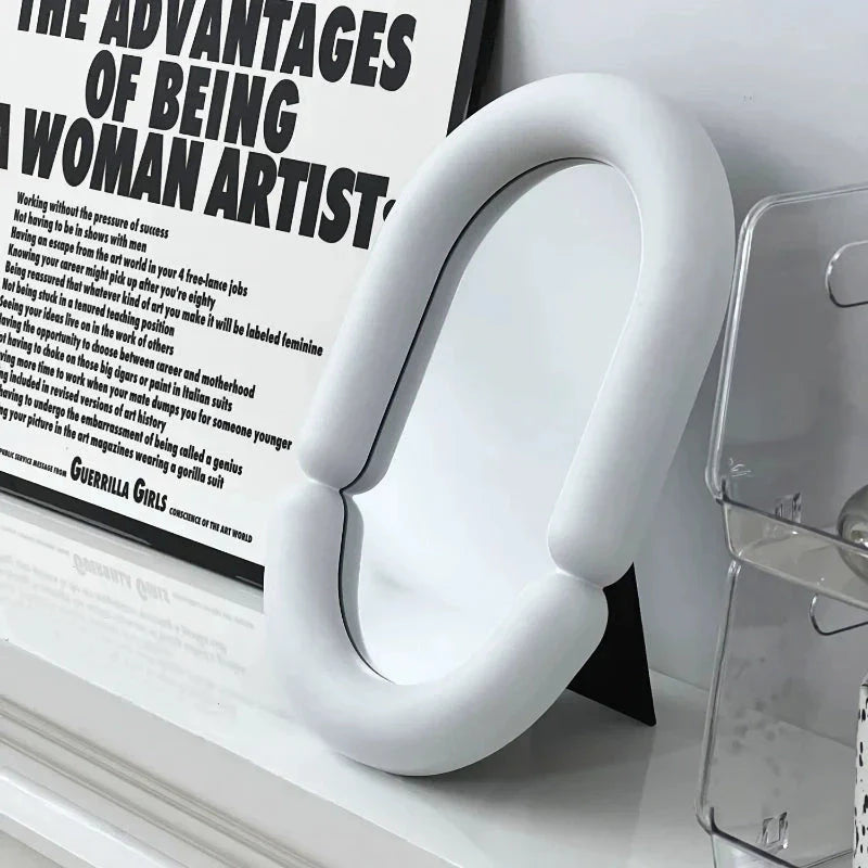 Elegant oval-shaped tabletop mirror with a sleek black plastic frame, perfect for adding a touch of sophistication to any room.