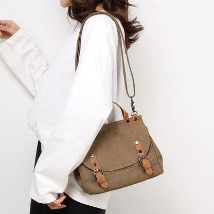A stylish women's canvas crossbody handbag in an orange color, featuring a small square shape and a horizontal design.