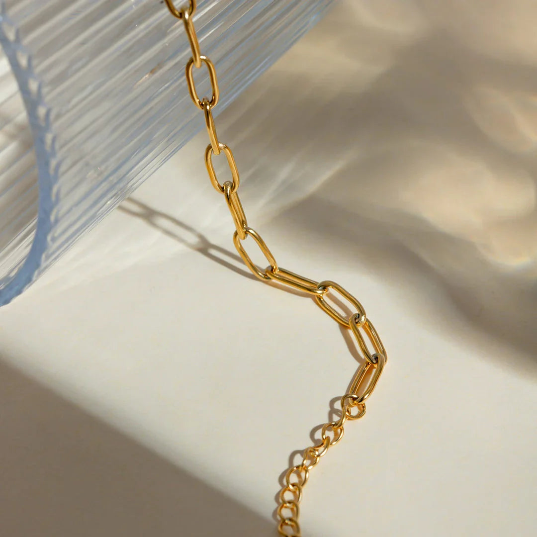 A close-up view of a 18K gold-plated stainless steel paper clip chain anklet, showcasing its elegant and minimalist design.