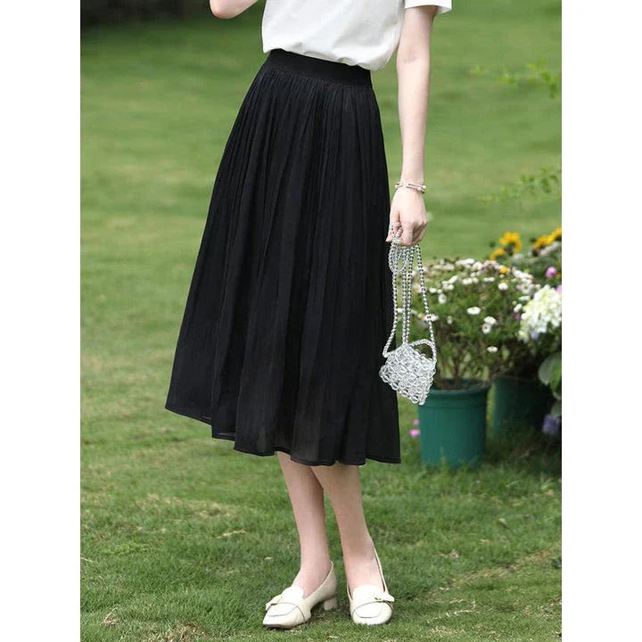Elegant satin pleated midi skirt in black, featuring a flowing A-line silhouette and natural waistline for a polished, feminine look.