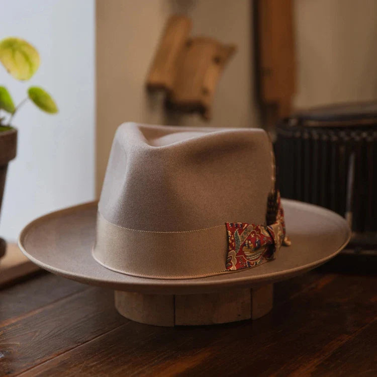 A beige wool top hat with a conical crown design, providing a classic and sophisticated look for formal and casual wear.