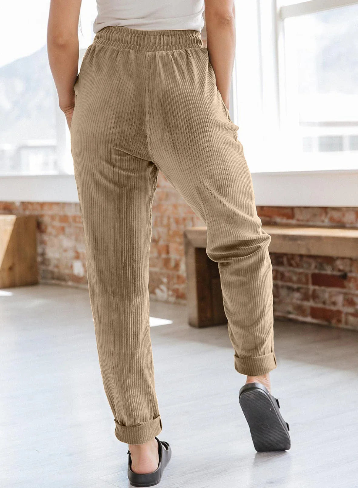 A pair of stylish corduroy pants for women with a wide-leg silhouette, elastic waistband, and side pockets.