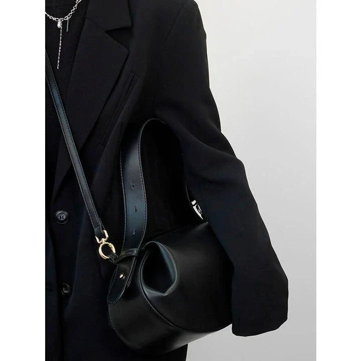 Circular vegan leather handbag in a tan color, with a sturdy build and thoughtful interior design for versatile use.