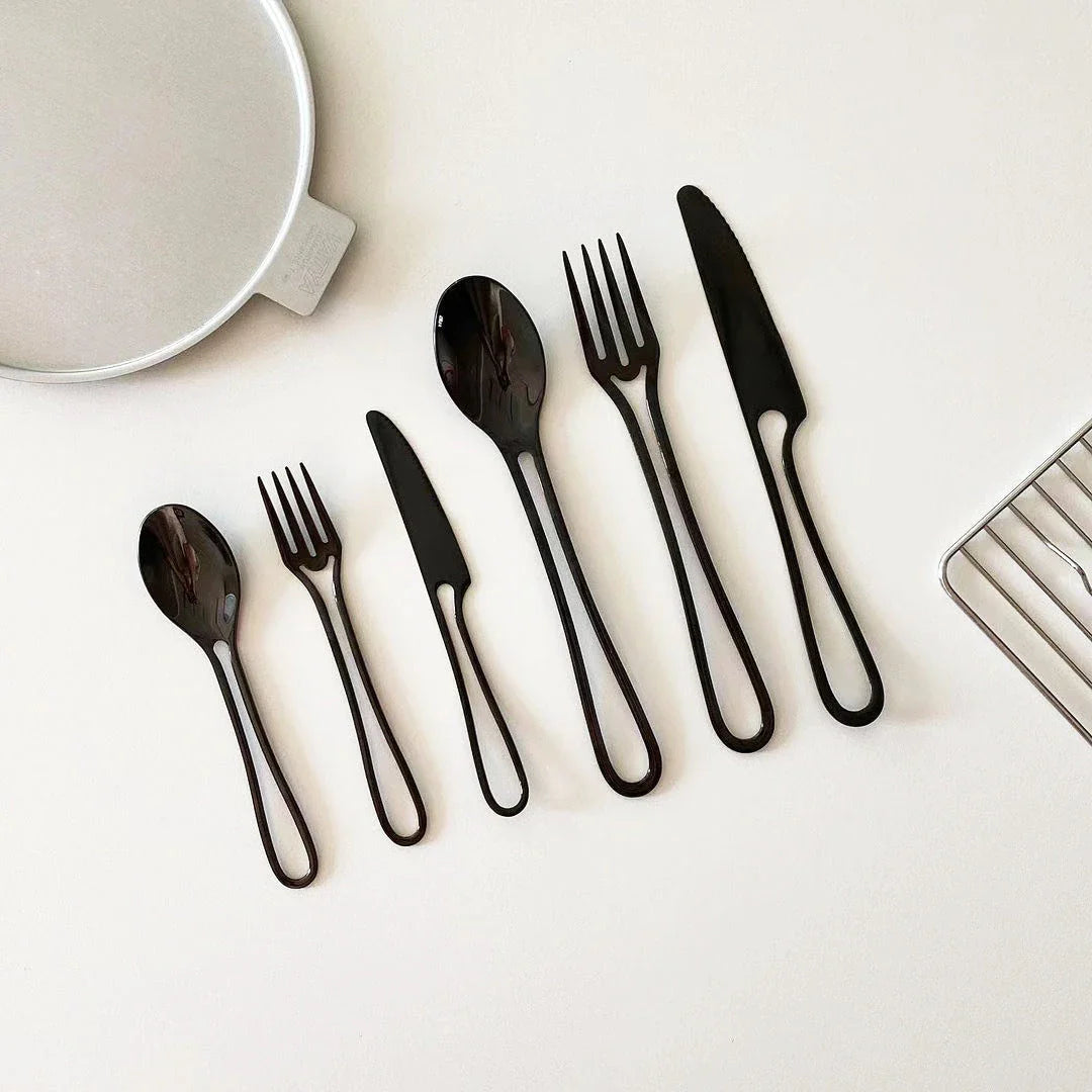 Sleek and modern 304 stainless steel cutlery set with a black finish, including knife, fork, and spoon for dinner and dessert.