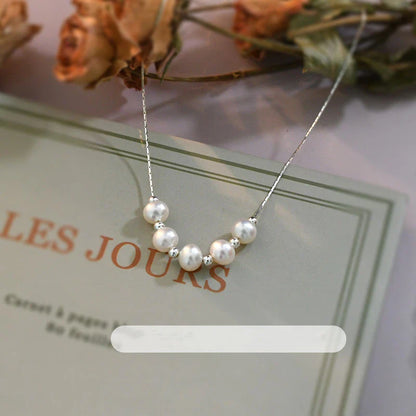 A close-up shot of a natural freshwater pearl necklace with a silver chain in a stylish multi-chain design.