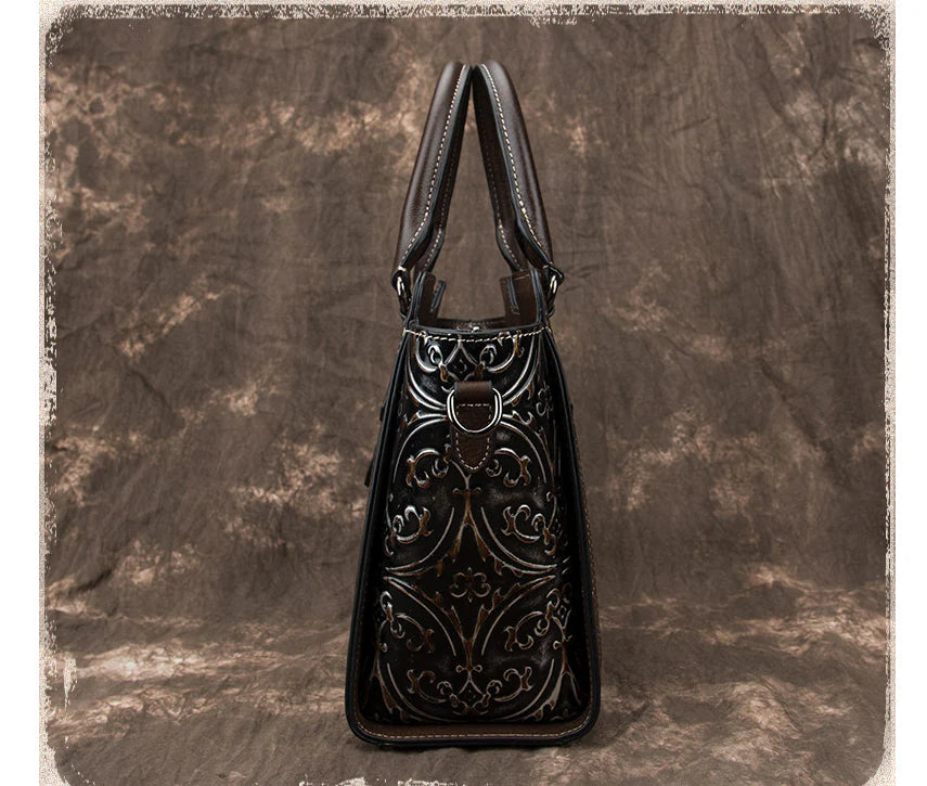 A fashionable large capacity leather shoulder bag for women in a vintage-inspired floral design with multiple interior pockets for organization.