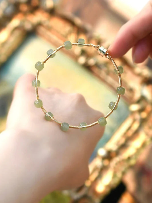 Elegant handcrafted Hetian jade bracelet with a captivating wave pattern, a sophisticated accessory that adds natural beauty to any outfit.