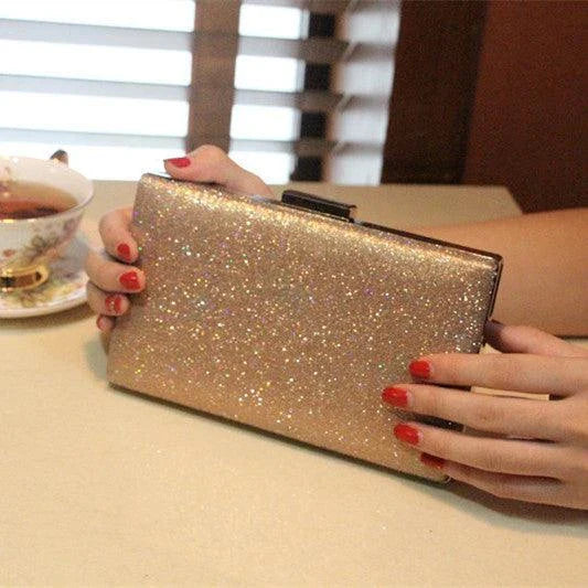 A shiny, metallic dinner clutch bag with a detachable chain strap for versatile carrying options