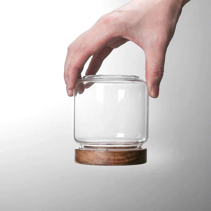 Airtight glass food storage jars with wooden lids in various sizes, perfect for organizing and preserving dry goods, spices, and pantry items in the kitchen.