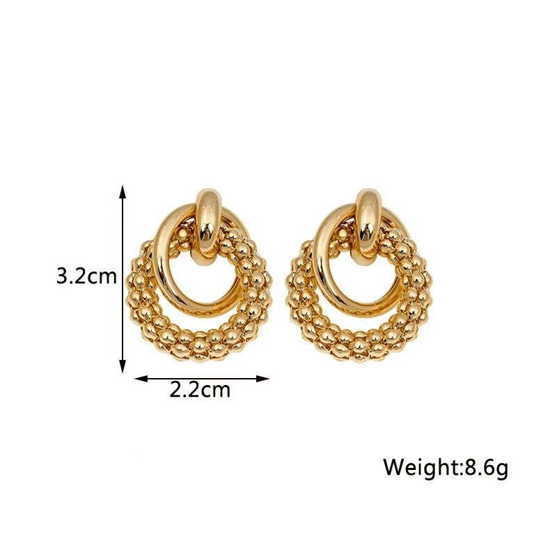 Elegant gold-toned twist dangle earrings with an intricate geometric design, perfect for adding a touch of sophistication to any outfit.