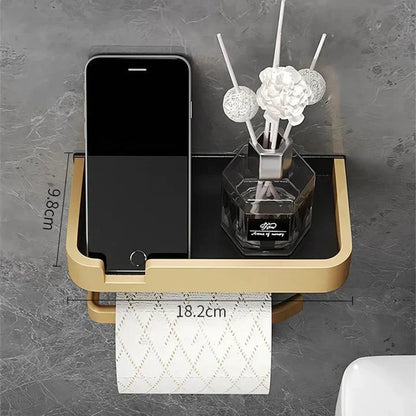 Black and gold aluminum bathroom paper holder with a convenient phone shelf, a stylish and functional accessory for modern bathrooms.