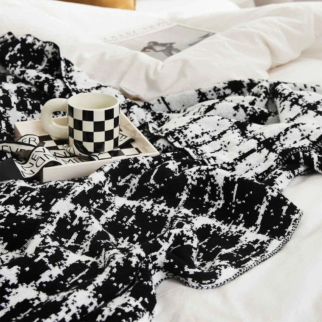 Luxurious white and black plaid wool knit blanket for cozy home, travel, and relaxation