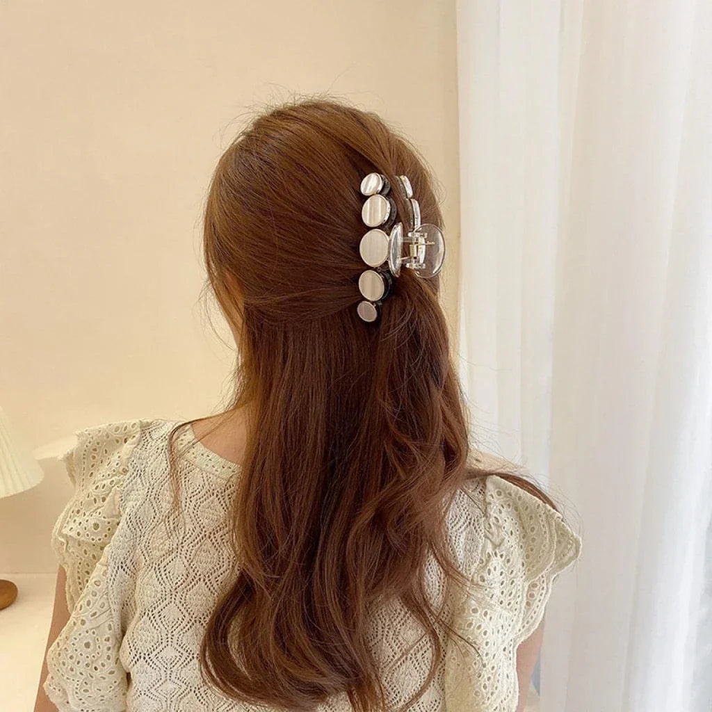 Elegant white marble circle hair claws that add a chic, fashionable touch to any hairstyle
