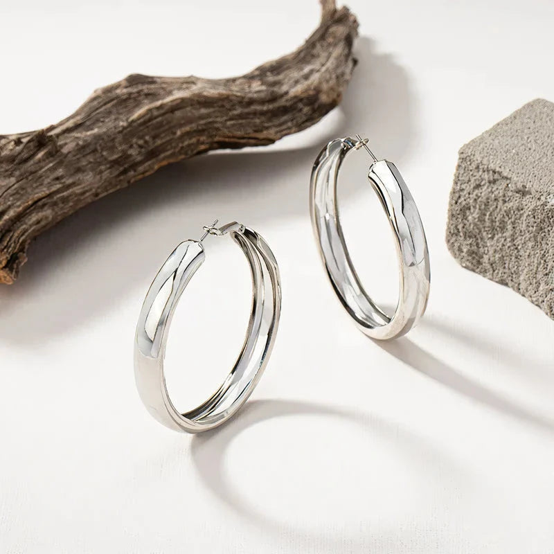 Glossy geometric metal hoop earrings in a silver finish, a trendy and versatile fashion accessory