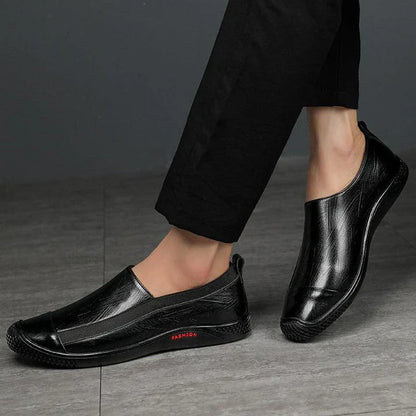 A pair of durable and stylish men's casual leather shoes in black, featuring a pointed toe, low upper, and rubber sole.